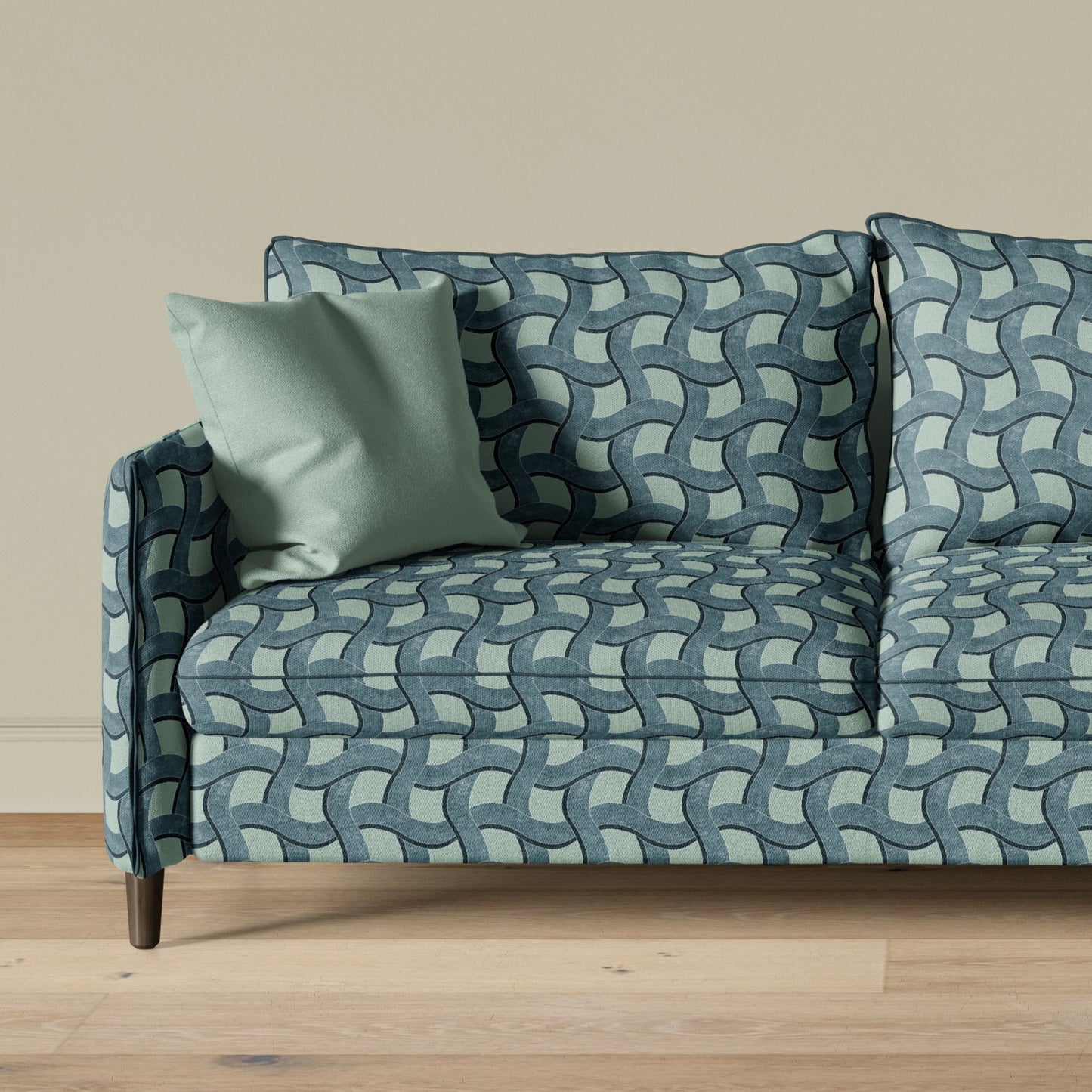 Blue patterned sofa with matching cushions on a wooden floor against a beige wall